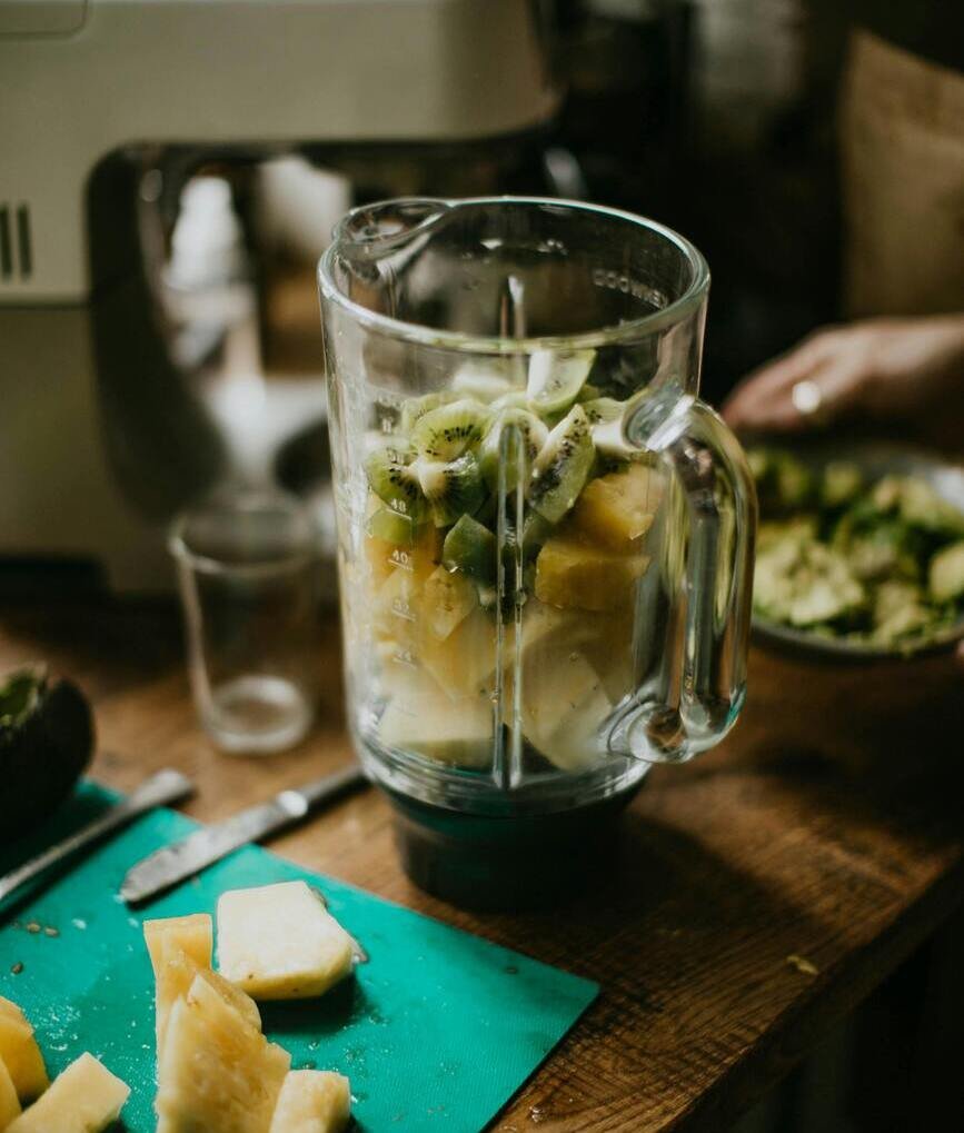 a blender full of fruits on a table